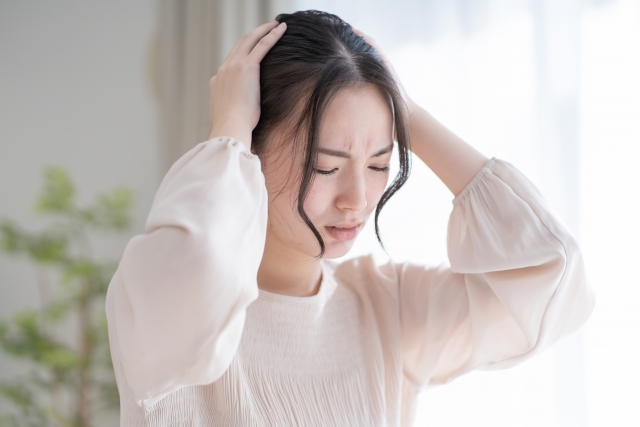 頭を抱えて悩む女性